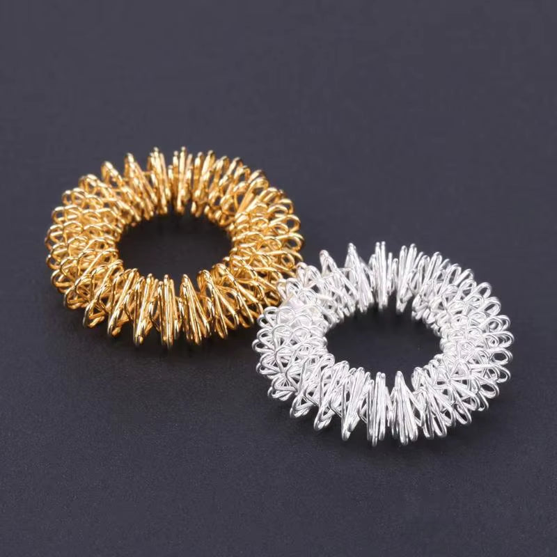 Anillo masajeador de acero para dedos: alivia dolor, reduce estrés y estimula la circulación. Compacto y fácil de usar.