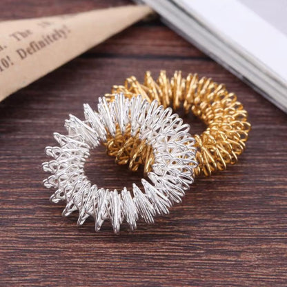 Anillo masajeador de acero para dedos: alivia dolor, reduce estrés y estimula la circulación. Compacto y fácil de usar.