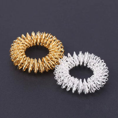 Anillo masajeador de acero para dedos: alivia dolor, reduce estrés y estimula la circulación. Compacto y fácil de usar.